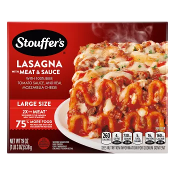 A plate of Lasagna with Meat & Sauce on a table below the product name, Large Size label, and "2x the Meat" label.