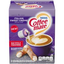 Una caja morada de porciones individuales de creamer Coffee mate Italian Sweet Cream con una etiqueta morada encima de una taza de café y un cannoli.