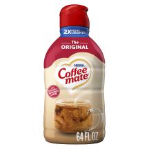A bottle of Coffee mate Original Creamer with a red cap and red label above a mug of coffee with biscotti.