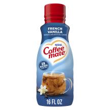Una botella azul de creamer Coffee mate French Vanilla con una tapa roja y una etiqueta azul sobre una taza de café y vainas de vainilla.
