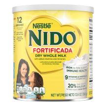 A canister of Nido Fortificada with a yellow label, white lid and gold heart above a glass of milk pouring.