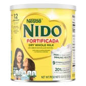 A canister of Nido Fortificada with a yellow label, white lid and gold heart above a glass of milk pouring.